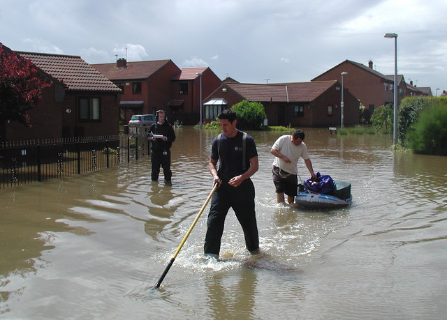 A firefighter helping a resident recover belongings from a flooded home in Burstwick, East Riding of Yorkshire